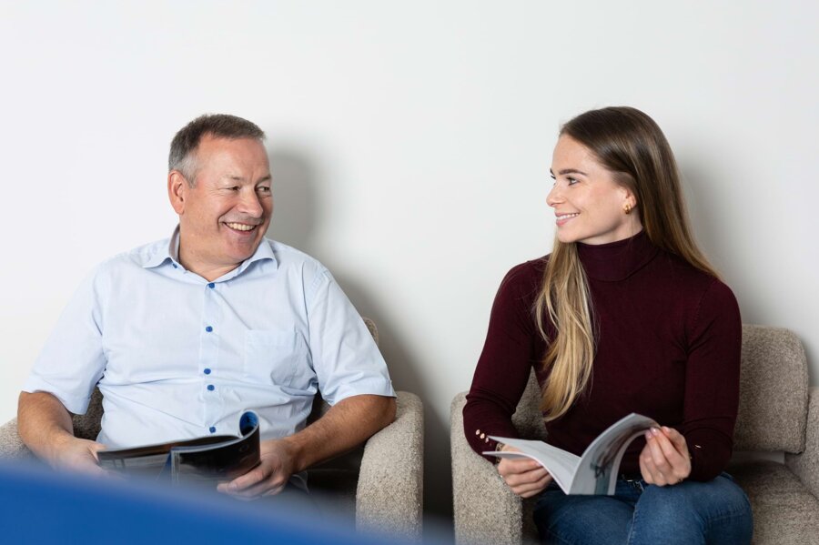 Ein Patient und eine Patientin unterhalten sich im Wartezimmer.