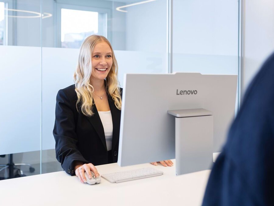 Eine freundliche Mitarbeiterin während der Terminvereinbarung in der modernen Praxis