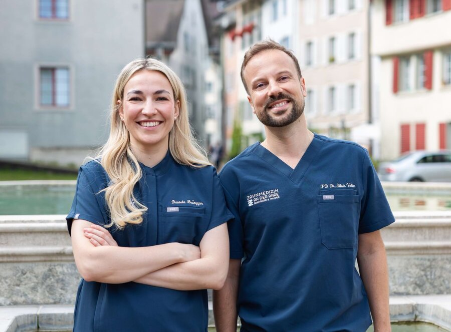 Nahaufnahme von Dr. Daniela Brüngger (links) und Dr. Silvio Valdec (rechts) vor einem Brunnen in Brugg