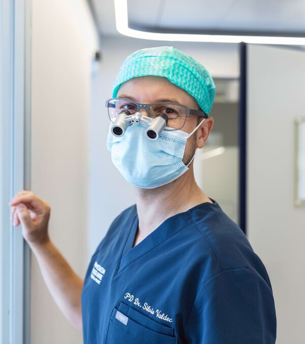 Dr. Silvio Valdec mit Mundschutz kurz bevor er das Behandlungszimmer betritt.