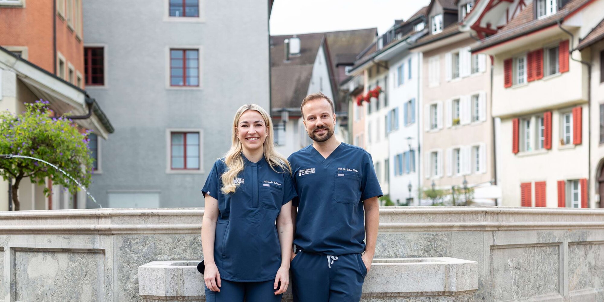 Dr. Daniela Brüngger (links) und Dr. Silvio Valdec (rechts) stehen vor einem Brunnen in Brugg.