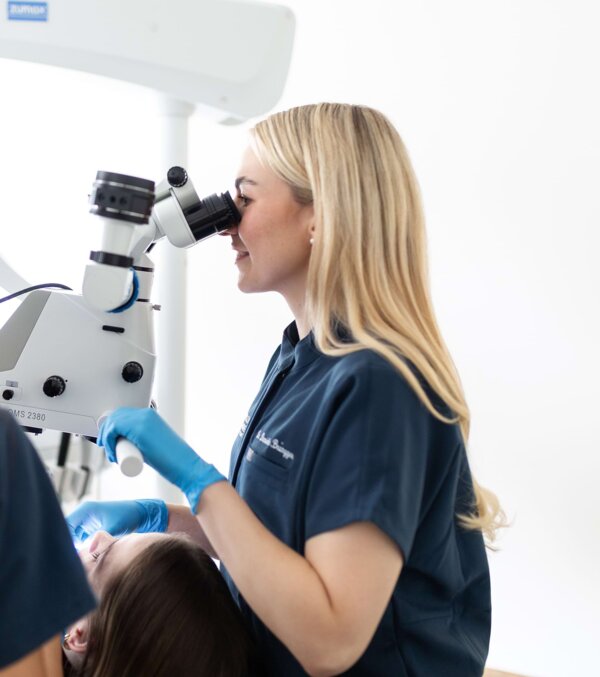 Dr. Daniela Brüngger untersucht eine Patientin am Mikroskop.