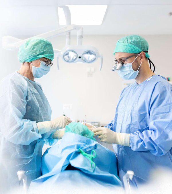 Situationsaufnahme von PD Dr. Silvio Valdec (rechts) und Assistenz (links) bei einem oralchirurgischen Eingriff
