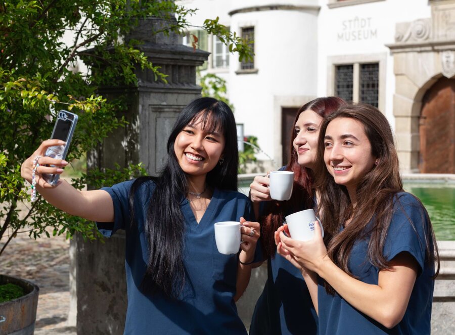 Drei Mitarbeiterinnen von Zahnmedizin an der Aare stehen in der Mittagspause in Brugg in der Sonne und machen gemeinsam ein Selfie.
