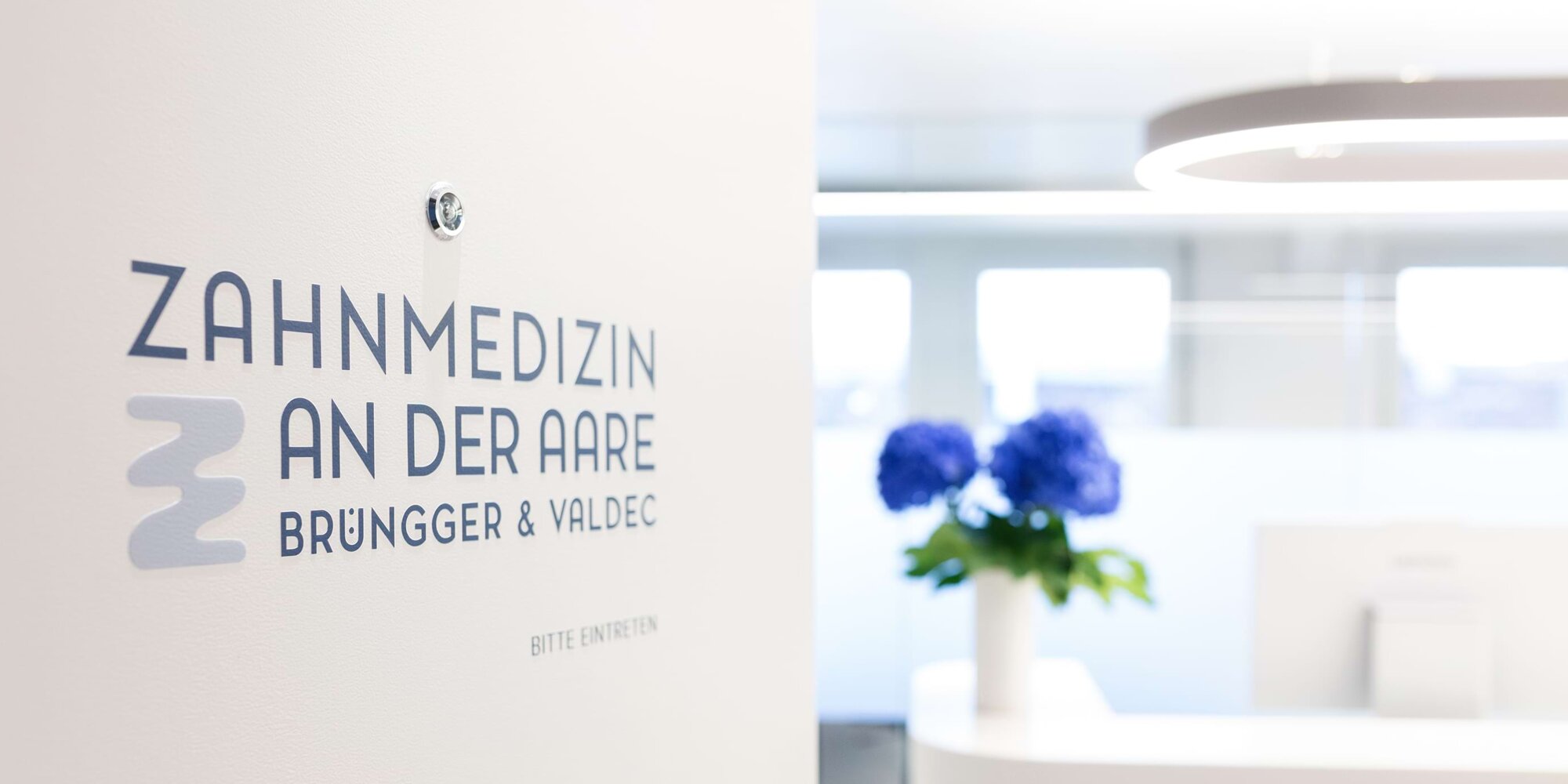 Impressionen vom Eingangsbereich der Praxis mit Fokus auf dem Logo